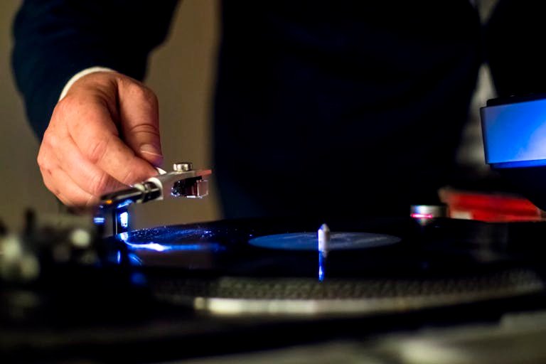 Person Holding a Phonograph's Tonearm