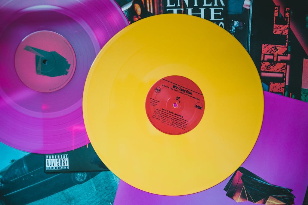 Vibrant yellow and pink vinyl records on colorful album covers.